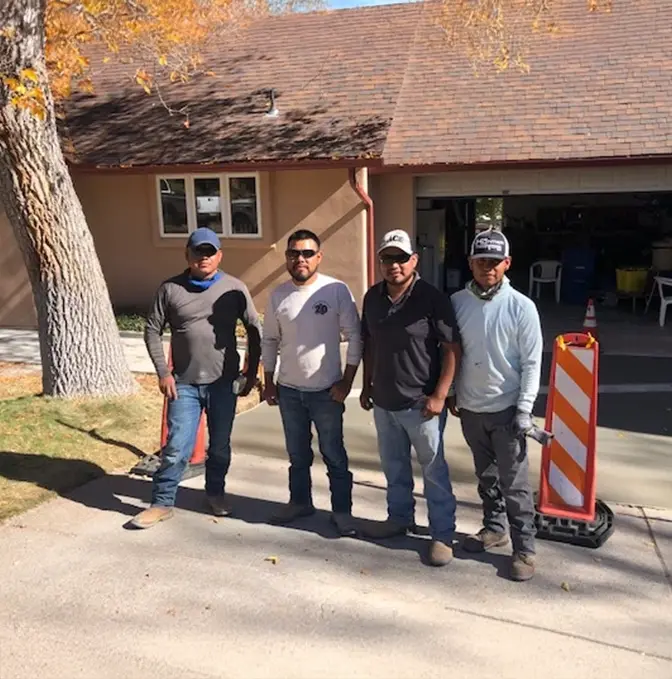 Los Alamos Landscaping team standing together at a residential job site, ready for work on a sunny day.